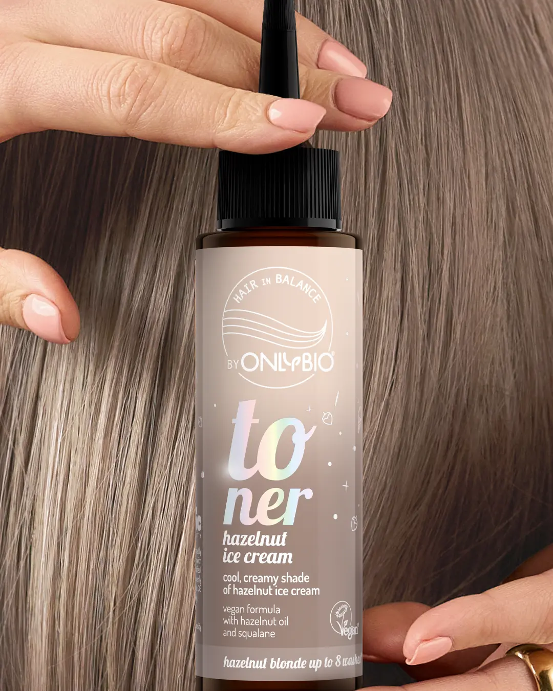 A bottle of OnlyBio hair toner against a background of hair