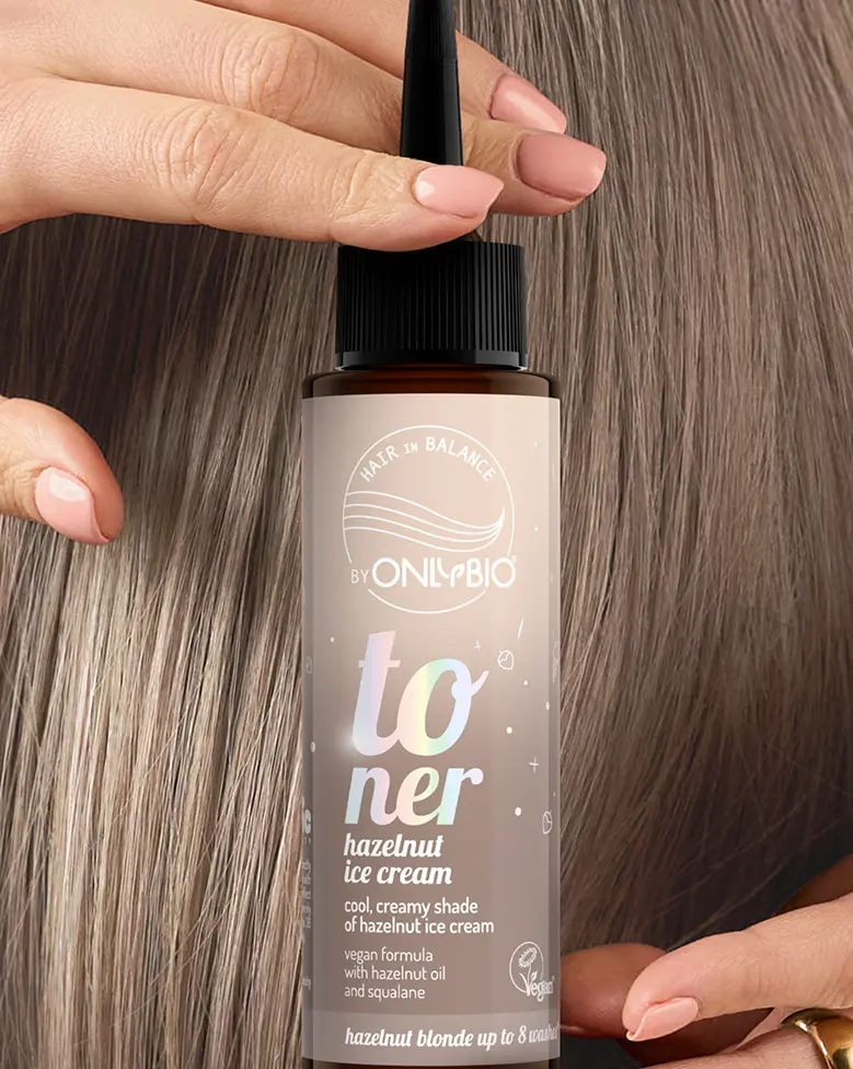 A bottle of OnlyBio hair toner against a background of hair
