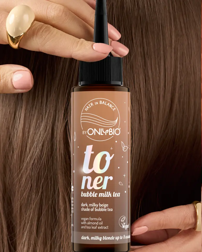 A bottle of OnlyBio hair toner against a background of hair