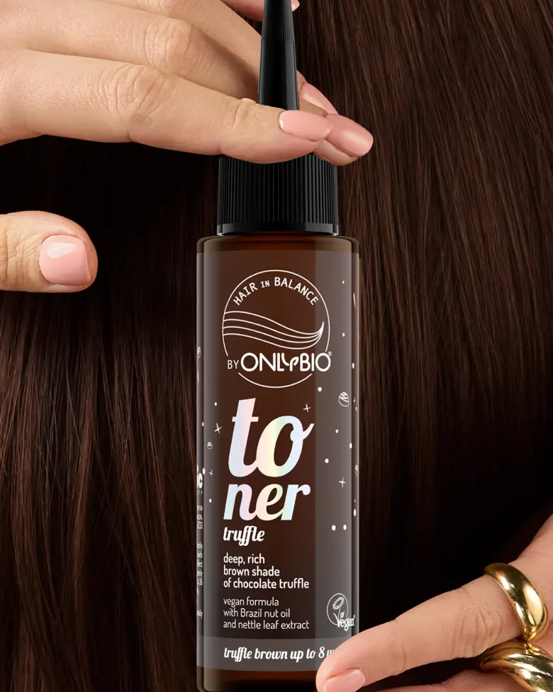 A bottle of OnlyBio hair toner against a background of hair